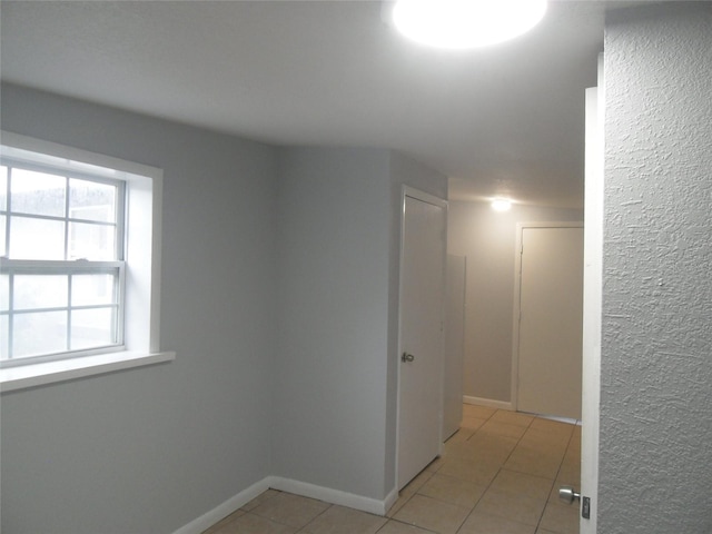 hall featuring light tile patterned floors