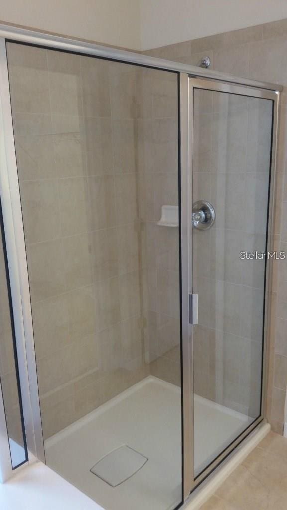 bathroom with tile patterned flooring and an enclosed shower