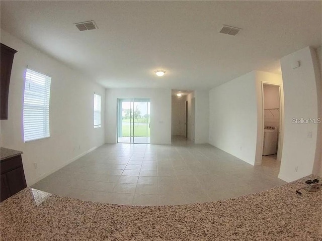 tiled spare room featuring washer / clothes dryer