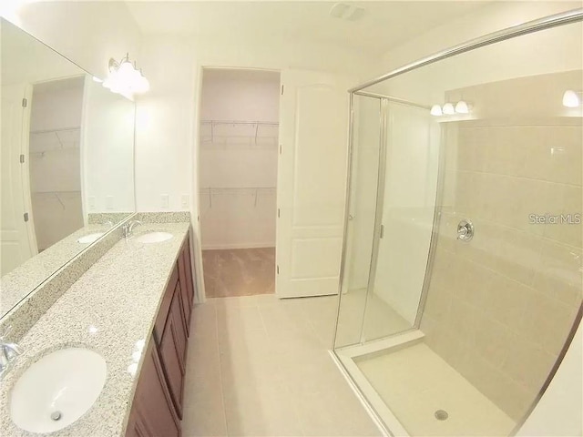 bathroom featuring tile patterned floors, vanity, and an enclosed shower