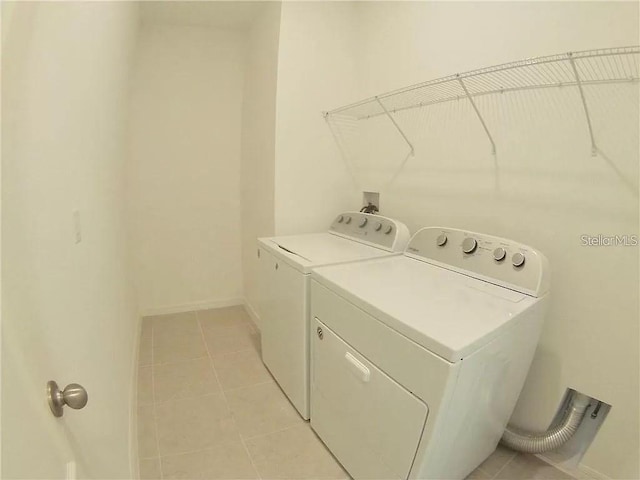 laundry room with independent washer and dryer and light tile patterned floors