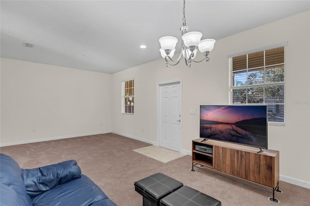 carpeted living room featuring a chandelier