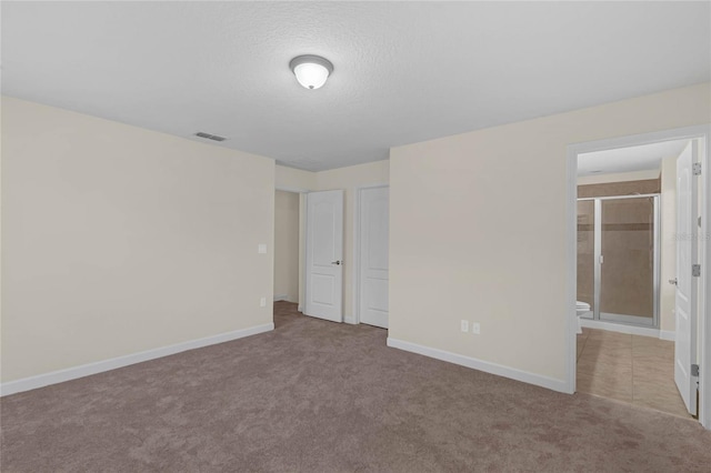 carpeted empty room featuring a textured ceiling