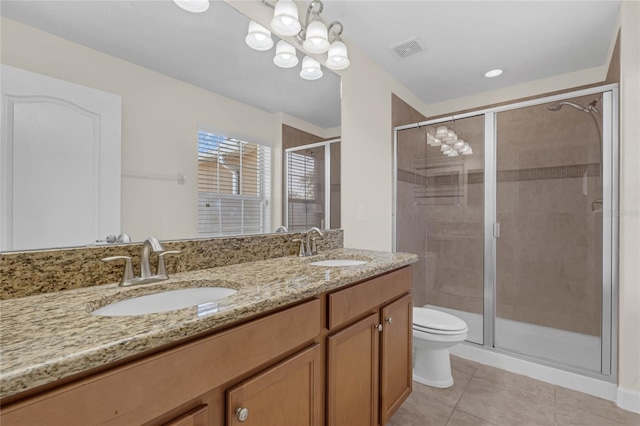 bathroom featuring vanity, an inviting chandelier, tile patterned floors, toilet, and a shower with shower door