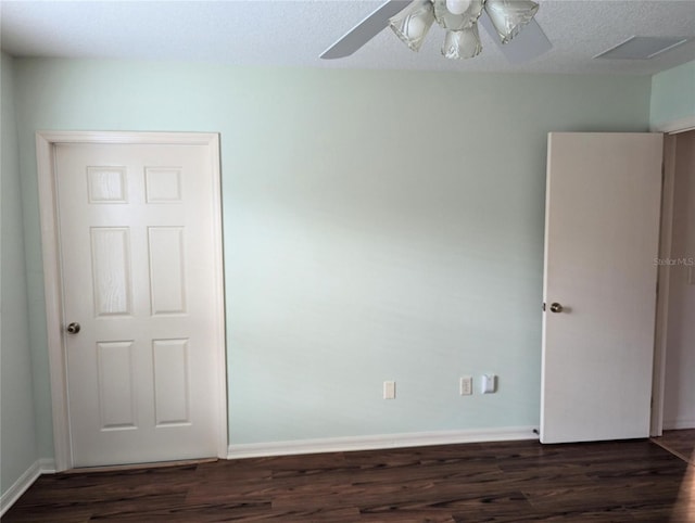 unfurnished room featuring dark hardwood / wood-style floors, ceiling fan, and a textured ceiling