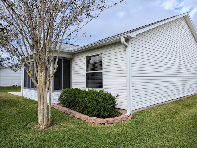 view of side of property with a sunroom and a yard