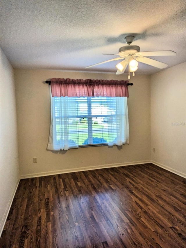 empty room with a textured ceiling, ceiling fan, and dark wood-type flooring