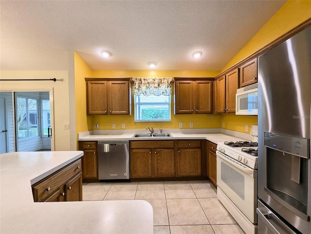 kitchen featuring a wealth of natural light, sink, appliances with stainless steel finishes, and vaulted ceiling