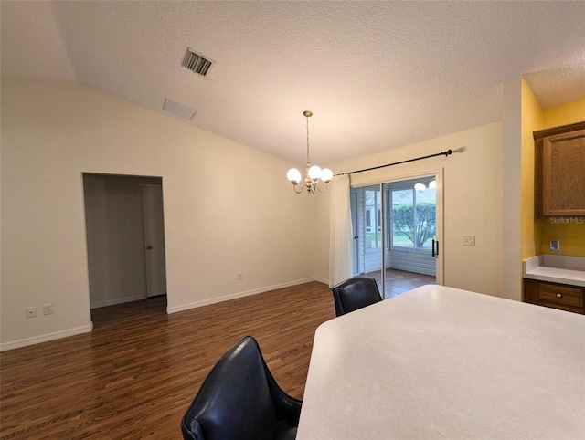 bedroom with dark wood-type flooring, a notable chandelier, a textured ceiling, vaulted ceiling, and access to outside