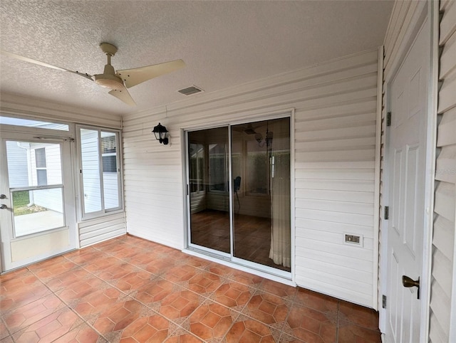 unfurnished sunroom featuring ceiling fan