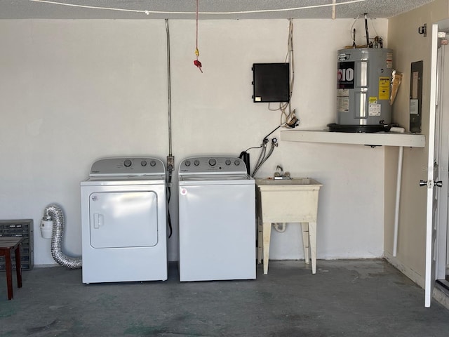 clothes washing area featuring a textured ceiling, electric water heater, and washing machine and clothes dryer