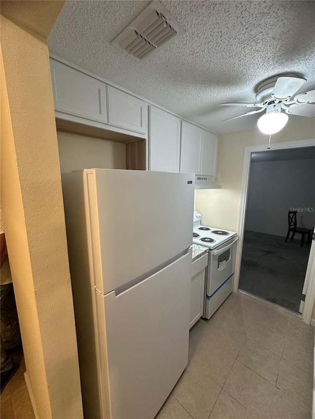 4944 Hazner St Unit 4944, New Port Richey, FL 34652 - kitchen with white appliances, under cabinet range hood, white cabinetry, ceiling fan, and light tile patterned floors