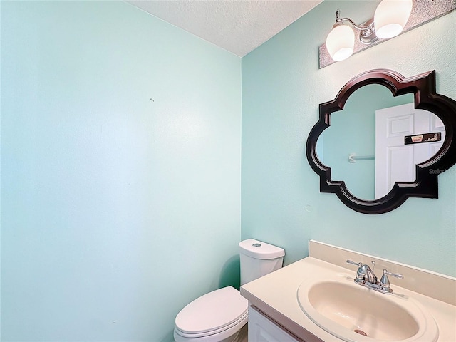 bathroom with vanity, a textured ceiling, and toilet