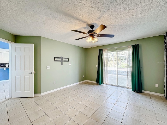 empty room featuring ceiling fan, light tile patterned floors, and a textured ceiling