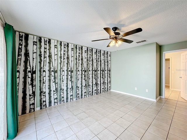 tiled empty room with a textured ceiling and ceiling fan