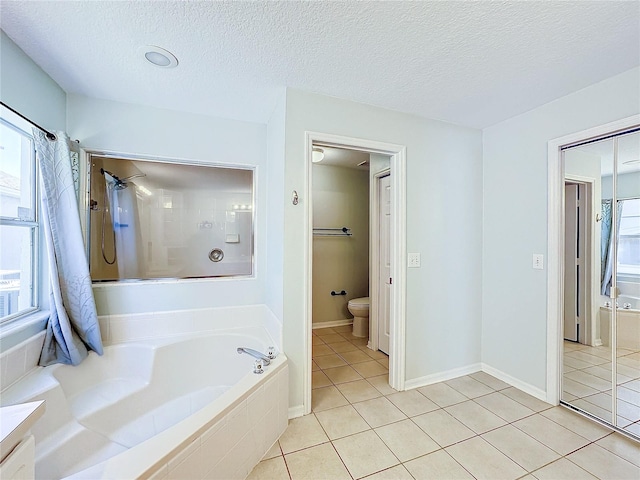 bathroom featuring tile patterned floors, shower with separate bathtub, a textured ceiling, and toilet