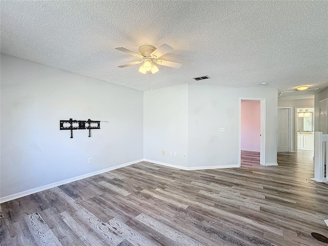 empty room featuring a textured ceiling, hardwood / wood-style flooring, and ceiling fan