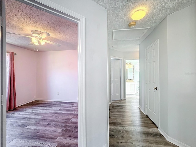 corridor with hardwood / wood-style floors and a textured ceiling