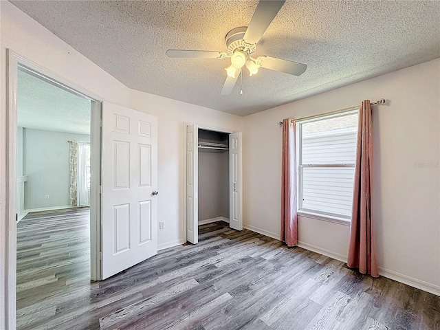 unfurnished bedroom with ceiling fan, a textured ceiling, and hardwood / wood-style flooring