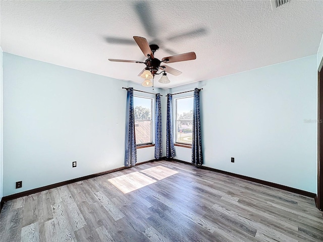 unfurnished room with ceiling fan, light hardwood / wood-style floors, and a textured ceiling