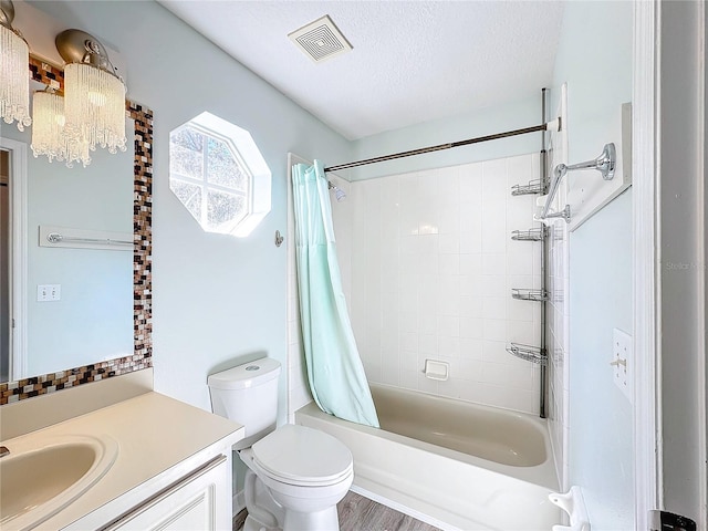 full bathroom with wood-type flooring, a textured ceiling, toilet, shower / bath combo with shower curtain, and vanity