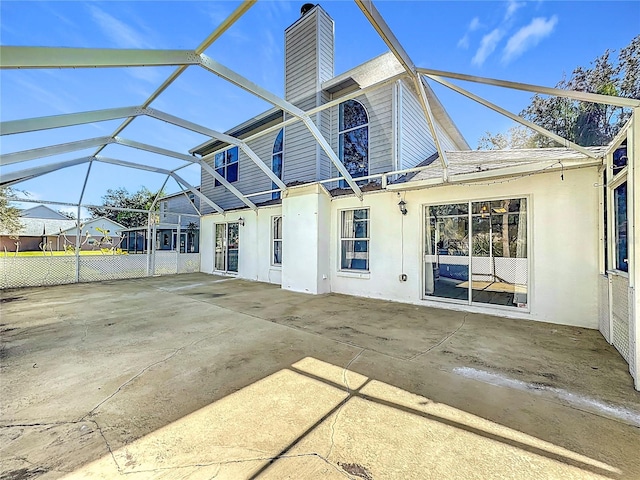 back of house with a lanai and a patio