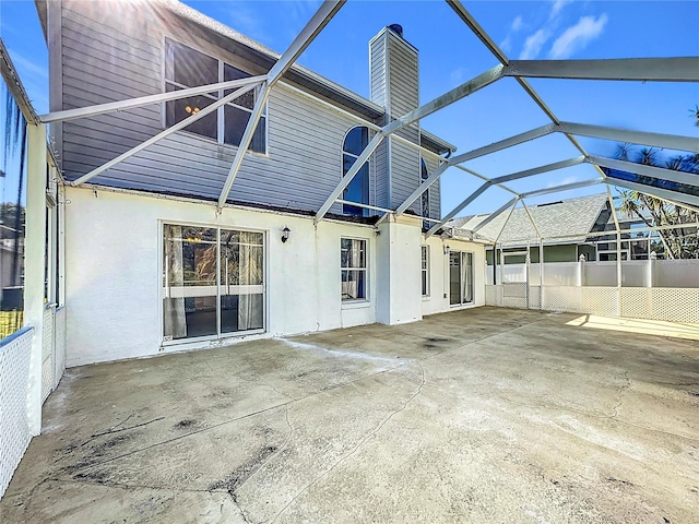 rear view of property featuring a lanai and a patio