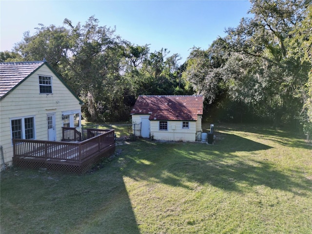 view of yard featuring a deck and a storage unit