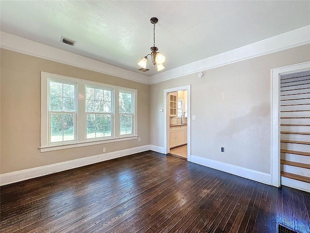 empty room with sink, dark hardwood / wood-style floors, and an inviting chandelier