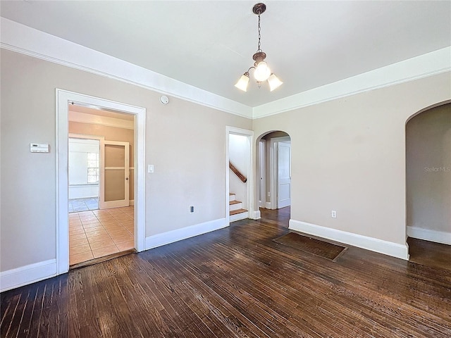 unfurnished room featuring a chandelier and dark hardwood / wood-style flooring