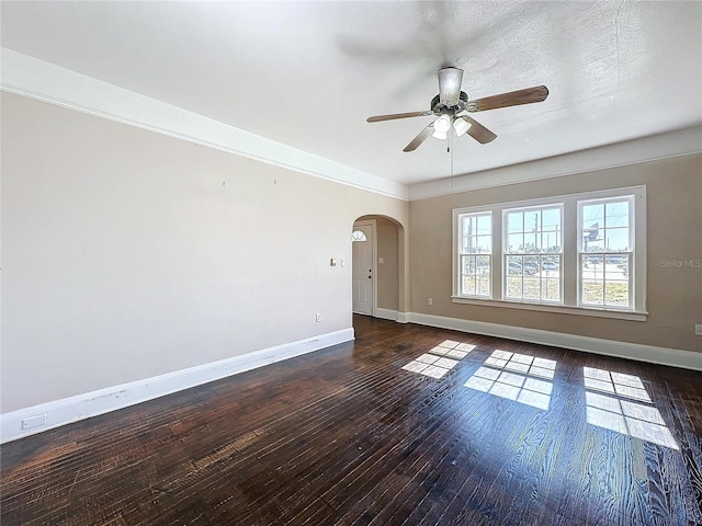 empty room with a textured ceiling, dark hardwood / wood-style floors, and ceiling fan