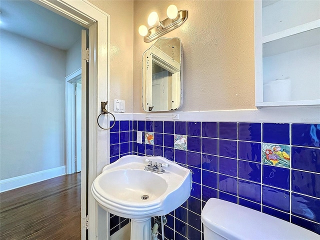 bathroom with sink, toilet, tile walls, and hardwood / wood-style flooring