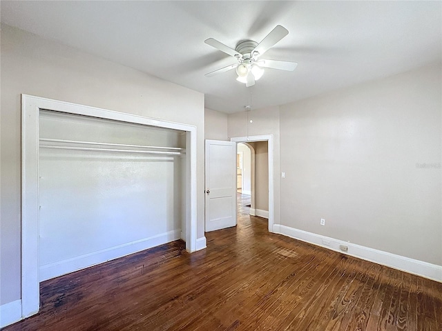 unfurnished bedroom featuring ceiling fan, a closet, and dark wood-type flooring