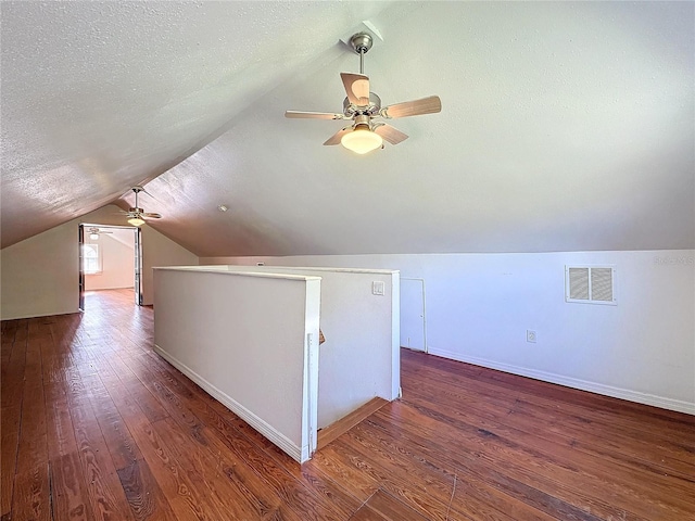 bonus room featuring ceiling fan, dark hardwood / wood-style flooring, a textured ceiling, and vaulted ceiling