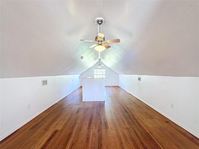 bonus room featuring dark hardwood / wood-style floors, ceiling fan, a textured ceiling, and vaulted ceiling