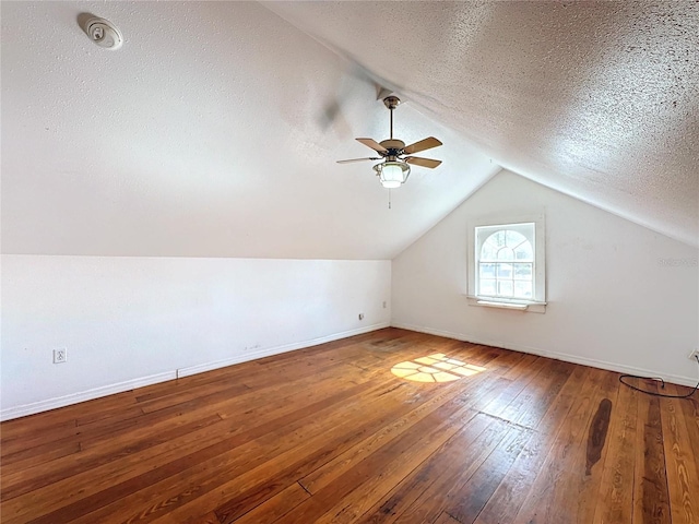 bonus room featuring hardwood / wood-style flooring, ceiling fan, lofted ceiling, and a textured ceiling