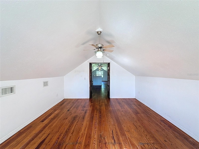 bonus room featuring dark hardwood / wood-style floors, ceiling fan, a textured ceiling, and vaulted ceiling