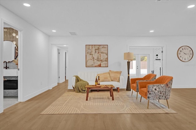 sitting room featuring french doors and light hardwood / wood-style floors