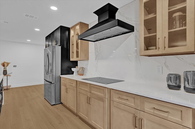 kitchen featuring backsplash, stainless steel fridge, light hardwood / wood-style floors, and range hood