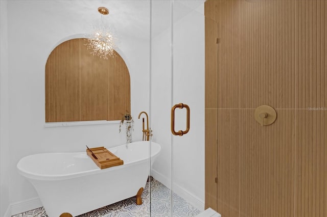 bathroom with tile patterned flooring, a bath, and a chandelier