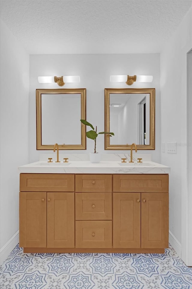 bathroom with tile patterned flooring, vanity, and a textured ceiling