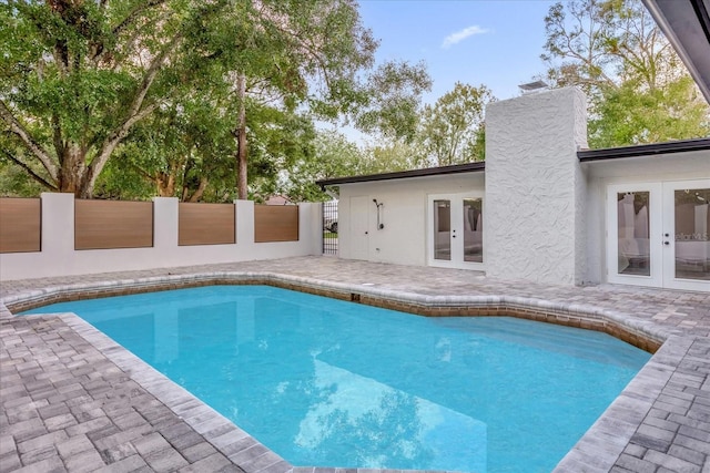 view of swimming pool featuring french doors and a patio