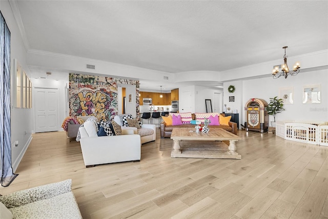 living room with a chandelier, light hardwood / wood-style floors, and ornamental molding