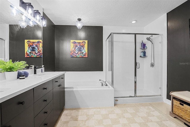 bathroom with separate shower and tub, vanity, and a textured ceiling