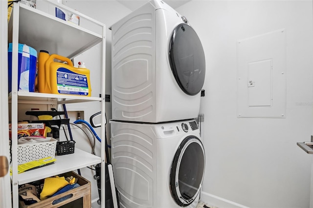 laundry room featuring stacked washer / dryer and electric panel