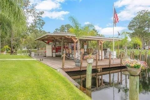 view of dock featuring a water view and a yard