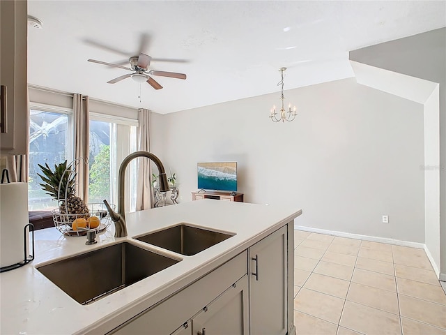 kitchen with decorative light fixtures, light tile patterned flooring, sink, and ceiling fan with notable chandelier