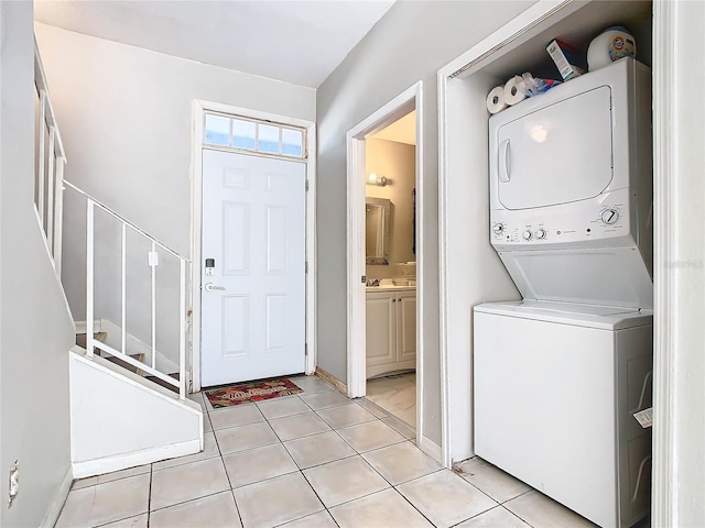 laundry room with light tile patterned flooring and stacked washer and clothes dryer