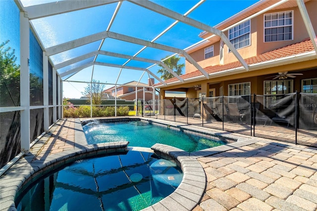 view of pool featuring ceiling fan, a patio area, an in ground hot tub, and glass enclosure