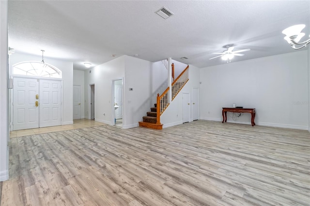 foyer featuring a textured ceiling, light wood-type flooring, and ceiling fan